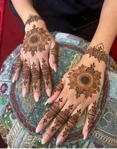 two hands with henna tattoos on them