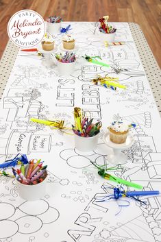 cupcakes and crayons are sitting on a table covered in coloring paper