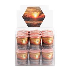 a display case with candles in it and an image of the sunset on the beach