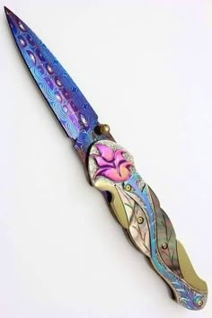 a multicolored knife with an intricate design on it's blade and handle