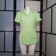 "Get ready to groove with this vintage green and white striped disco blous! This short-sleeve button-up collared blouse will add a touch of retro charm to your wardrobe.  Crafted from 100% polyester, this blouse is both thick and durable while remaining lightweight for your comfort. The excellent craftsmanship and care put into this piece are evident, making it a high-quality find.  Dating back to the late 60s to early 70s, it's perfect to wear during the spring and summer months, but can also be layered to keep you stylish during colder weather. Although there are no care symbols, this item is machine washable. The original white buttons are still intact and in working condition, although it looks like the top button has been reinfoced in the past (see pic.) The pointy disco mod collar ad 60s Blouse, Vintage Party Theme, 70s Blouse, Disco Shirt, Collared Blouse, Mid Century Mod, Vintage Theme, Top Summer, Spring Tops