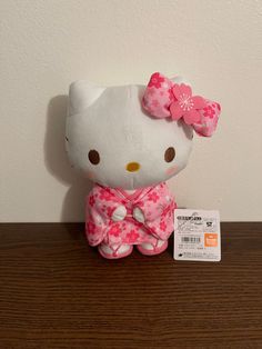 a hello kitty stuffed animal sitting on top of a wooden table