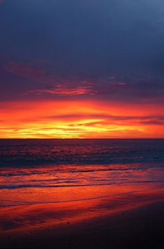 an orange and blue sunset over the ocean