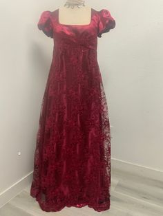 Beautiful burgundy/wine dress made with embroidered sequined mesh over satin perfect for the regency ball or tea party very shiny . Please not it takes me 5-8 business days to produce and ship your dress after order is placed . THERE IS NO RETURNS OR EXCHANGES ACCEPTED PLEASE BE SURE TO CHECK THE MEASUREMENTS ON THE BOTTOM OF THE DESCRIPTION. If for any reason the measurements don't match with yours be sure to provide to me at the time of order. PLEASE NOTE COLOR MAY BE A LITTLE DIFFERENT ONCE Y Regency Inspired Prom Dress, Regency Dress Casual, Regency Dress Black, Red Regency Gown, Burgundy Ball Gown For Party, Burgundy Ball Gown Evening Dress, Burgundy Ball Gown For Prom Season, Festive Formal Lace Evening Dress, Burgundy Ball Gown For Evening