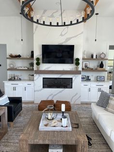 a living room filled with furniture and a flat screen tv mounted on the wall above a fireplace