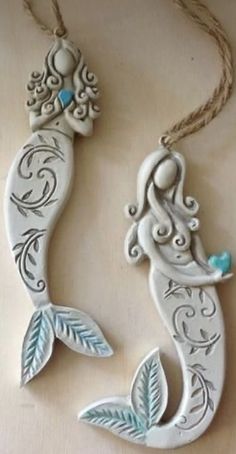 two ceramic mermaid ornaments hanging on a string