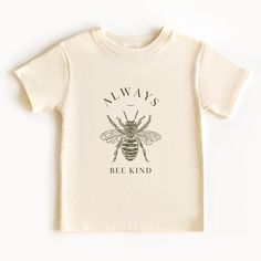 Uplift any child's wardrobe with a custom kid's t-shirt. The Bella Canvas short sleeve tee for toddlers is a 100% Airlume combed and ring-spun cotton jersey with a tear-away label for extra comfort. Choose your favorite color out of a big variety, and make unique staples that toddlers will happily wear every day.  .: 100% airlume combed and ring-spun cotton (fiber content varies for different colors) .: Extra light fabric (3.9 oz/yd² (132 g/m .: Tear-away label Organic Cotton Short Sleeve Top With Custom Print, Organic Cotton Tops With Custom Print And Short Sleeves, Toddler Tshirt Ideas, Bee Shirt, Bee Kind, Kids Tops, Cotton Fiber, Kids Shirts, Favorite Color