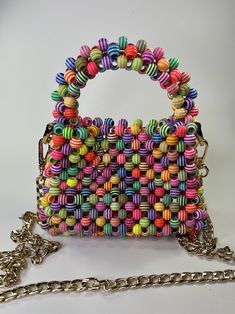 Made with colorful striped plastic beads. Magnetic closure and gold shoulder chain. 6"X2X7" (including handle) Multicolor Rectangular Bag With Pearl Handle, Multicolor Rectangular Bag With Colorful Beads, Multicolor Rectangular Shoulder Bag With Colorful Beads, Multicolor Plastic Bags As Gift, Multicolor Beaded Bags For Gifts, Multicolor Shoulder Bag With Chain Strap As Gift, Bead Purse, Wedding Bags, Beaded Handbag