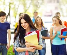 a group of young people walking down the street with notebooks in their hands stock photos