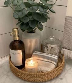 a basket with candles, soap and other items in it sitting on a bathroom counter