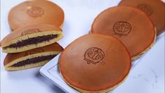 some cookies are sitting on a plate and one is cut in half to show the logo