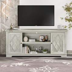 a flat screen tv sitting on top of a wooden entertainment center in a living room