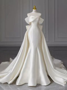 a white wedding dress on display in a room