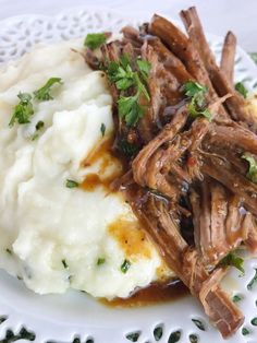 a white plate topped with meat and mashed potatoes