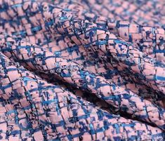 the fabric is blue and pink with small squares on it's edges, as well as an abstract design