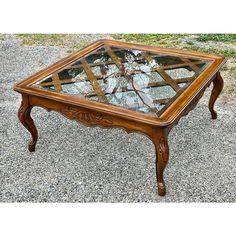 a wooden table with glass top on gravel