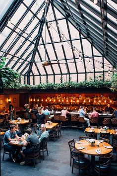 the inside of a restaurant with tables and people sitting at them eating food in it