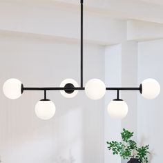 This 6-Light sputnik modern Linear chandelier pendant light is a great blend of modern classic and transitional styles. It's shaped in modern linear and glass globes , featuring matte black finish and white frosted opal glass shades, , which looks low-profile but has the elegant and minimalist aesthetics. The glass sphere hanging light is an eye-catching and focal piece to help complete a timeless interior decor, is ideal for over kitchen island and dining room table, or in a living room and hot Pendant Lights Over Dining Table, Chandelier Over Island, Modern Chandelier Foyer, Modern Black Chandeliers, Lights Over Dining Table, Modern Linear Chandelier, Signal Hill, Minimalist Dining Room, Dining Chandelier