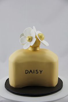 there is a cake that has flowers on it and the words daisy written in black