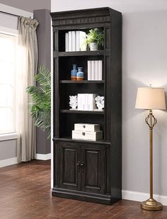 a book shelf with books on it and a lamp next to it in a living room