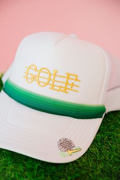 Get ready to hit the green with this unique GOLF RIBBON WHITE TRUCKER HAT! Featuring a gold Golf patch and a green ombre ribbon, this hat combines style and sport in one. Plus, a golf tee patch on the bill adds a playful touch. A must-have for any golf enthusiast (or fashionista)! This is a made-to-order item. All customized orders are currently shipping within 14 business days. To receive item quicker, expedited shipping is available at checkout. Adjustable White Trucker Hat For Golf, White Curved Brim Trucker Hat For Golf, White Trucker Hat, Ribbon White, Golf Tee, Golf Tees, The Bill, Green Ombre, One Plus