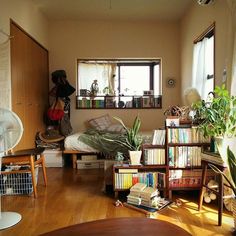 a living room filled with lots of books and plants