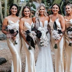 a group of women standing next to each other in front of cacti plants