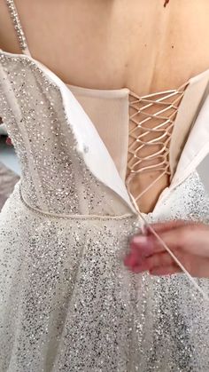 a woman in a white dress is holding on to some string attached to her back