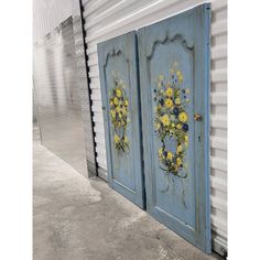 two blue doors with yellow flowers painted on them