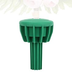 a close up of a vase with flowers in it on a white background and green stand