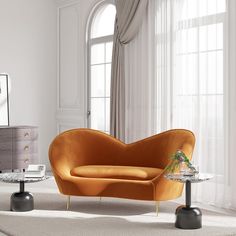 a living room with an orange couch and two side tables in front of a window