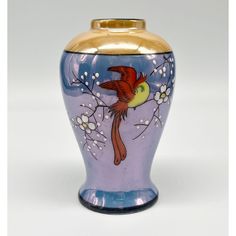 a blue vase with a bird painted on it's side and flowers in the bottom