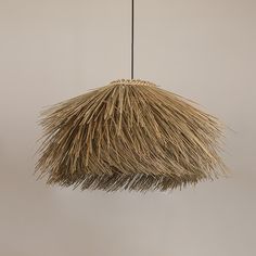 a light that is made out of straw and hanging from a ceiling fixture in a room