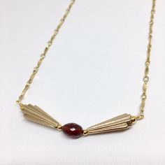 "Do you love the Art Deco design period? Do you love Garnet? Do you love wearing unique one-of-a-kind artisan jewelry? If you answered yes to these questions then this amazing necklace deserves to be yours! Lightly curved, flat, Gold Fill links are linked together in an amazing chain. From the chain are Art Deco inspired light Bronze charms in a quintessential Art Deco fan design. They are a light Bronze but look like vintage gold. In the center of the Bronze charms i a gorgeous, clear, faceted, Art Deco Inspired Jewelry, Red Gemstone Jewelry, Red Garnet Jewelry, 1920s Jewelry, Art Deco Fan, Fan Design, Garnet Necklace, Art Deco Necklace, Garnet Jewelry