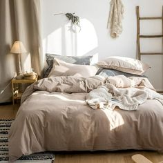 an unmade bed in a bedroom with white walls