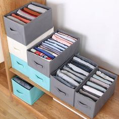 three bins are stacked on top of each other with folded shirts in the bottom