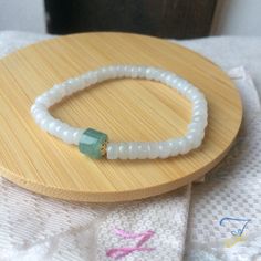 "Dainty Grade A Burmese Icy Jadeite Jade Beaded Bracelet, Grade A Burma icy White Jadeite, Guatemalan Icy Blue Green Jade, 14KGF, 簡約冰膠翡翠手串 This bracelet is made of 14k gold filled pieces, Burma icy white jade, and Guatemalan icy blue green jade. This bracelet is threaded by a white elastic thread, it's ajustable. Those white jade beads have an gélatinous and slightly icy foundation. Some of those beads have visible structure traces (inside) and their forms aren't all in rondelle. The blue jade bead is of Guatemalan icy jade. This jade has an icy transluscent foundation. This jade has a very intense stone structure, it's a very good quality jade. The golden pieces are of 14k gold filled. --------------------------------------------------------------- Les photos sont prises avec le produit r Hand-strung White Jade Beaded Bracelets, White Jade Crystal Bracelet, White Jade Crystal Bracelet With Natural Stones, White Jade Spiritual Bracelets, White Adjustable Jade Bracelets, White Jade Crystal Bracelet For Healing, White Jade Crystal Healing Bracelet, Adjustable Faceted White Crystal Bracelet, White Spiritual Jade Bracelets