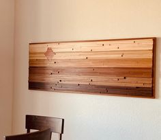 a wooden wall hanging on the side of a white wall next to a dining room table