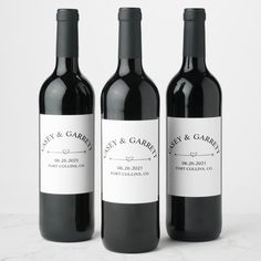 three bottles of wine sitting next to each other on a white counter top, with one bottle labeled cheers