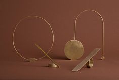 three metal objects on a brown background, one with a measuring tape and the other without