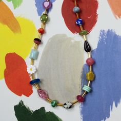 The Mariposa Beaded Necklace is fun personified. This multicolored, beaded necklace is sure to make you smile. This necklace is handmade using an assortment of beads including Czech glass and gemstone beads on a single strand of colorful loveliness! While each bead might have a different color, consistency, pattern, texture and shape, they are all separated by a cylindrical golden bead. This allows for you to really be able to see the unique beauty of the necklace and still have unity in the des Artsy Multicolor Beaded Necklace, Colorful Gemstone Beaded Necklaces With Round Beads, Colorful Gemstone Beaded Necklaces, Multicolor Czech Glass Gemstone Beads, Whimsical Multicolor Beaded Necklaces, Adjustable Colorful Gemstone Beaded Necklaces, Whimsical Necklaces With Heart And Round Beads, Playful Beaded Necklaces With Colorful Beads For Gifts, Playful Beaded Necklace With Colorful Beads For Gift