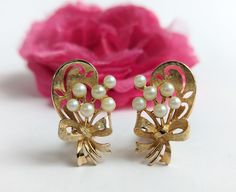 Lovely mid century, 1960s era clip on earrings. Gold tone base featuring an abstract floral bouquet design with faux, plastic pearl accents. Unsigned. In very good vintage condition. Some normal signs of age and gentle use with some light wear to the surfaces and pearls. No major rub wear or chipping to the finishes. Clips are in good working order and hold securely when fastened. Measurements are as follows and are approximate: Length- 1 3/16" Width- 3/4" Garden Cottagecore, Elegant Garden, Bouquet Design, Floral Bouquets, Abstract Floral, Earrings Gold, Clip On, Faux Pearl, Clip On Earrings