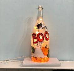 a lighted boo bottle sitting on top of a shelf