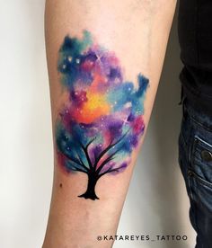 a colorful tree tattoo on the arm