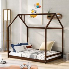 a child's bed with a wooden frame and canopy, in a white room