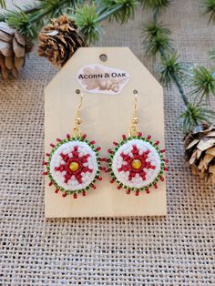 These Poinsettia themed Yellow Agate Beaded Medallion earrings are hand beaded by a registered Tribal Artist of the Choctaw Nation. Ruby red, emerald green and pearl glass seed beads create a seven printed poinsettia flower motif around a center 4mm yellow agate stone. The earrings hang from a gold-tone nickel free ear wire and have a green felt backing for comfort. Handmade Jewelry For Holiday Celebration, Handmade Holiday Jewelry For Celebration, Beaded Dangle Christmas Jewelry, Christmas Beaded Dangle Jewelry, Beaded Jewelry For Christmas Celebrations, Handmade Red Flower Earrings For Festive Occasions, Handmade White Beaded Earrings For Christmas, Handmade Jewelry For Christmas Celebration, Handmade Flower Earrings For Festive Occasions