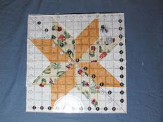 a quilted star on top of a blue table cloth with buttons and holes in the center