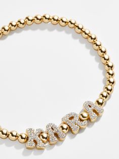 We took our best-selling Custom Pisa Bracelet and gave it a blast from the past when designing our Retro version. Pavé letter beads in a nostalgic, bubbly font are flanked by our signature Pisa gold ball beads. A singular bead sits in between each letter, letting them all get their individual spotlight. Even better? This design is a stretch bracelet, meaning you can take it on and off with ease. Whether you pick a name, phrase or place, we're certain this is a piece you'll want to keep in your e Custom Name Bracelet, Gold Bracelet With Pearls, Bubbly Font, Preppy Jewelry, Wishlist 2024, Bride Outfits, Early Black Friday, Blast From The Past, Jewelry Accessories Ideas