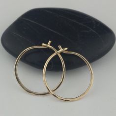 "Lovely, delicate Solid 14k Gold Hoop earrings Larger size earrings come with a set of rubber ear wire backs to prevent loss. 5/8\" and 2.75\" sizes photographed; 2\" size shown in video METAL: Solid 14k Yellow Gold WIRE GAUGE/DIAMETER: 20 gauge (0.8mm) wire - Standard ear wire thickness FINISH OPTIONS: Choose from plain round wire or lightly hammered texture EARRING DIAMETER SIZE: Approximately 1/2\", 5/8\"(Pictured), 3/4\", 1\", 1.25\", 1.5\", 1.75\", 2\" (in video), 2.25\", 2.5\", 2.75\" (pho Dainty Recycled Gold Round Hoop Earrings, Dainty Recycled Gold Hoop Earrings, Delicate 14k Yellow Gold Hoop Earrings, 14k Yellow Gold Hoop Earrings With Ear Wire, Delicate Hypoallergenic Yellow Gold Hoop Earrings, Handmade 14k Gold Hoop Earrings For Everyday, Handmade Adjustable 14k Gold Hoop Earrings, Hand Forged Yellow Gold Hoop Earrings, Adjustable Handmade 14k Gold Hoop Earrings