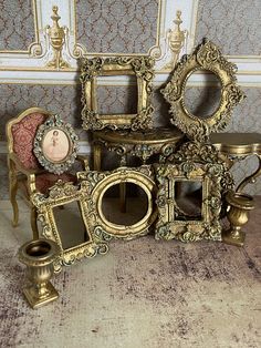 an assortment of antique furniture and mirrors on the floor in a room with ornate wallpaper